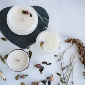 A Variety of White Candles with Flowers in Round Containers