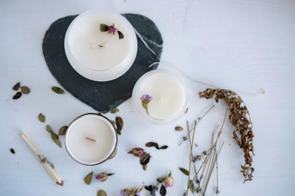 A Variety of White Candles with Flowers in Round Containers